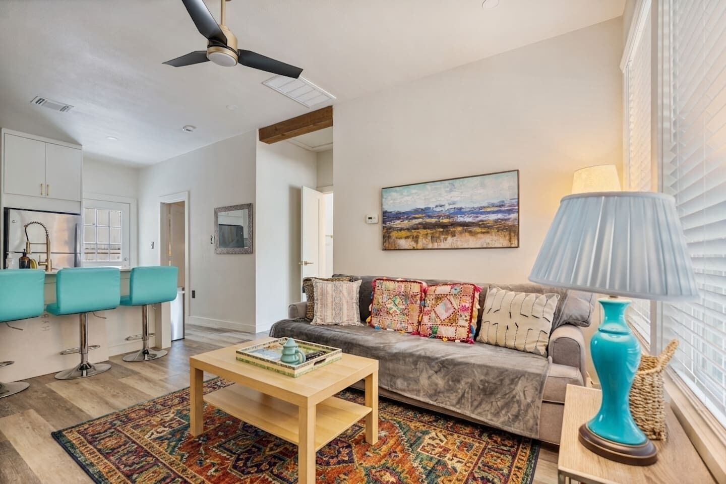 A living room with a sofa, a coffee table, a lamp, and a painting on the wall.