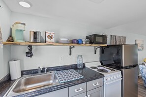 A compact kitchen with a sink, stove, microwave, and refrigerator. - Sparrows Nest - Nestled in the Heart of Oriental (Oriental)