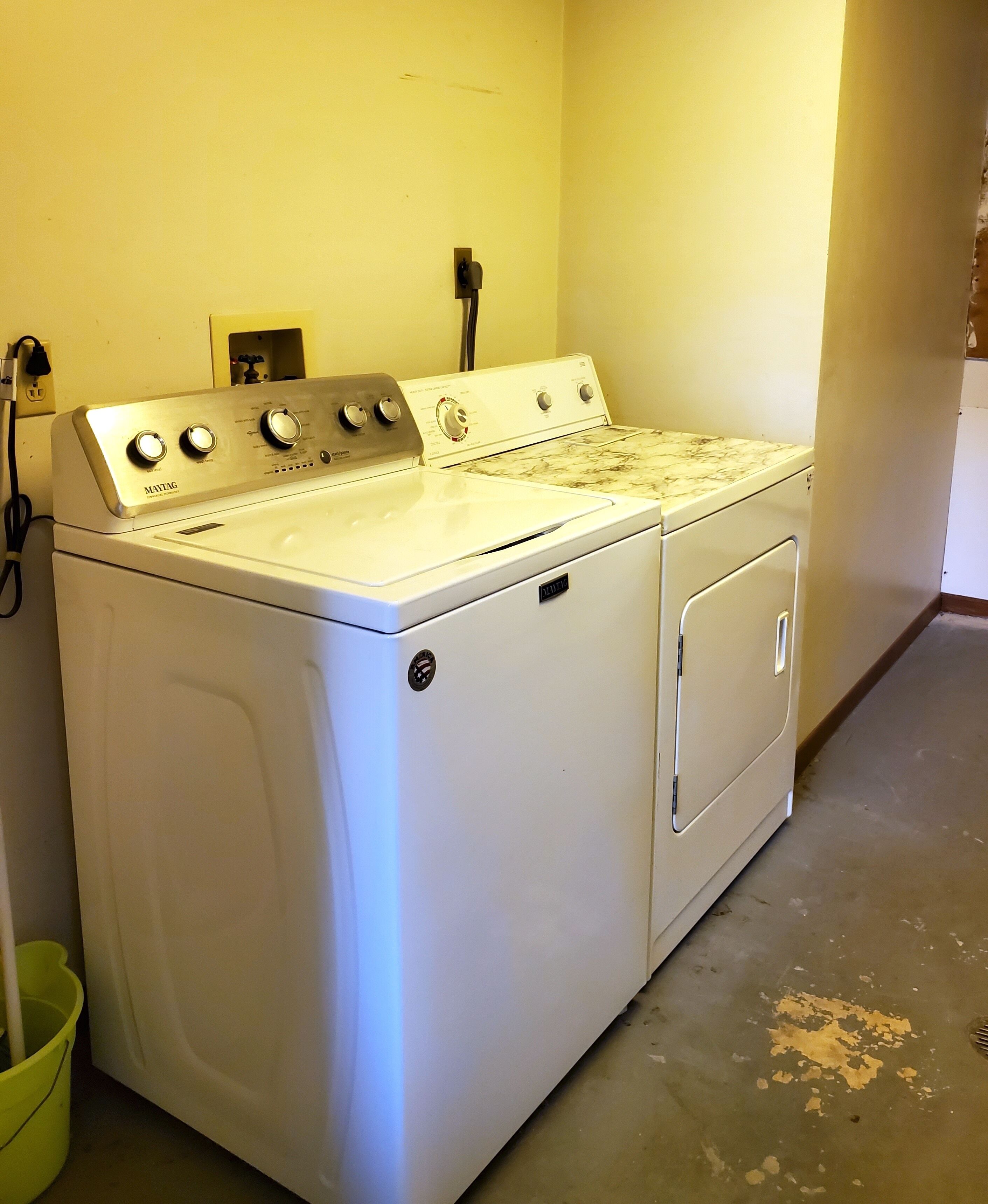 A white washing machine with four dials, a control panel, and a door with a handle.