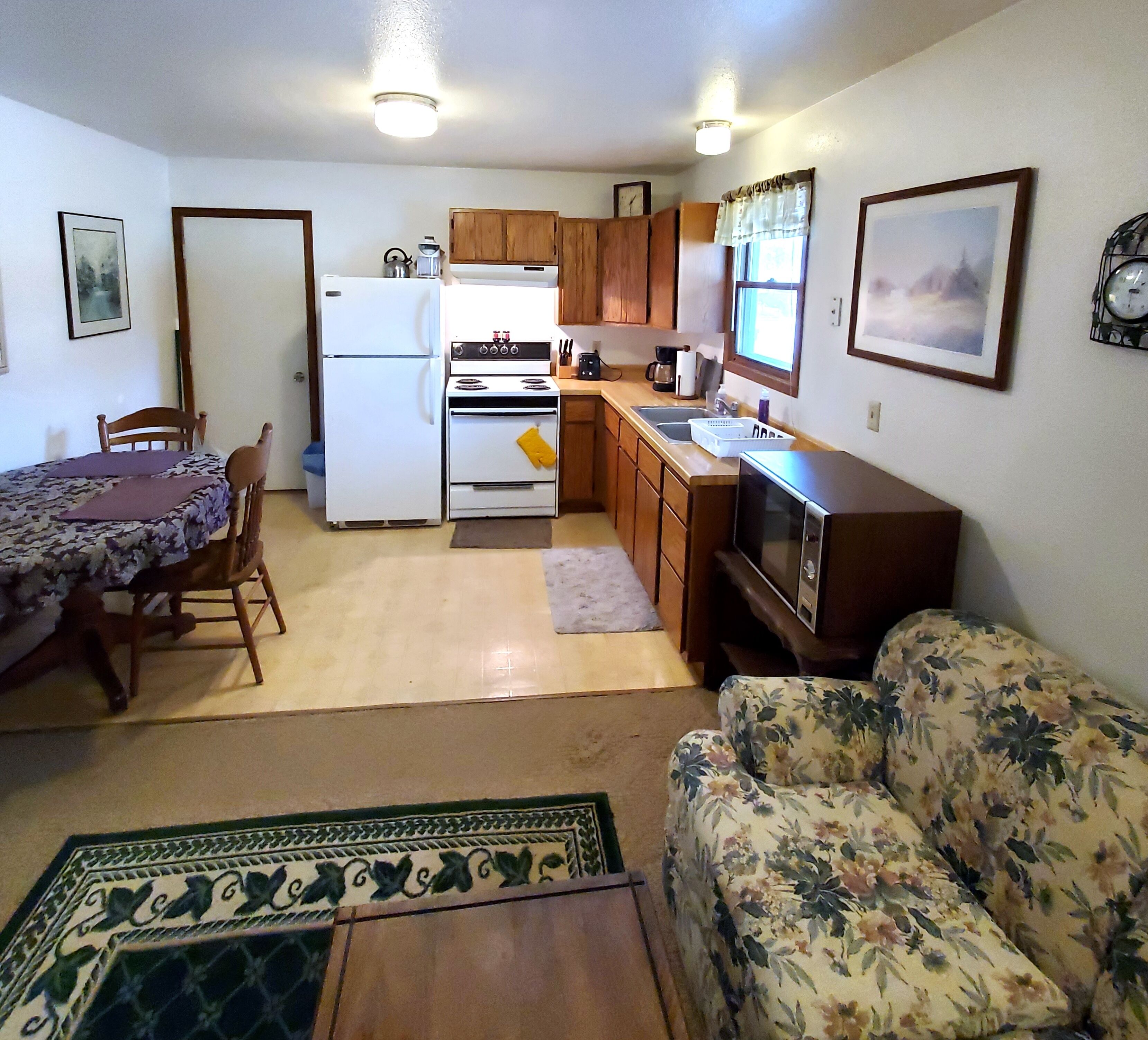 A compact living space with a kitchenette, a dining area, and a sofa.