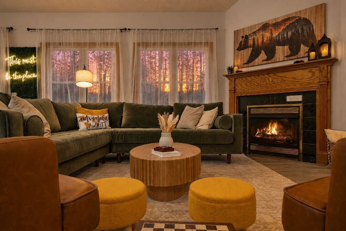 Una sala de estar acogedora con un sofá modular, una chimenea y un amplio ventanal con cortinas.