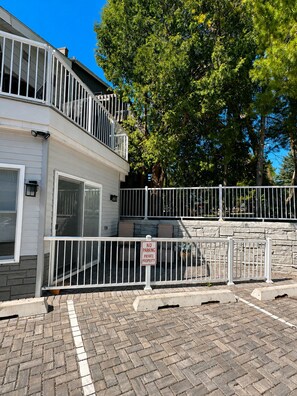 A two-story building with a gated entrance, a no parking sign, and a brick-paved area. - The Haven - Downtown Egg Harbor Retreat (Egg Harbor)