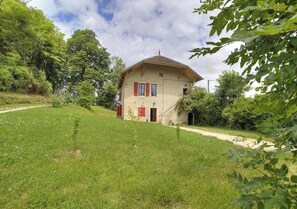 Ein einstöckiges Haus mit geneigtem Dach, einer kleinen Veranda und einem Weg zum Eingang.