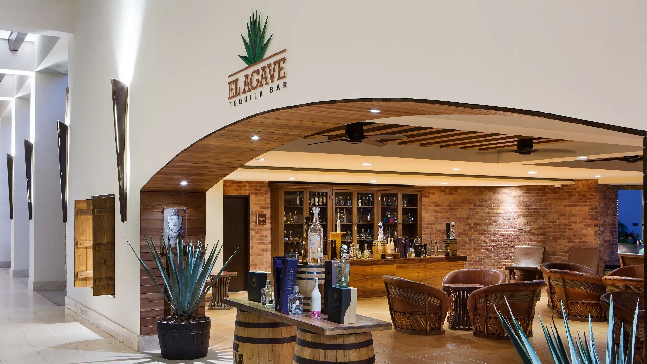 A bar with a wooden ceiling and a sign reading 'EL AGAVE Tequila Bar'.