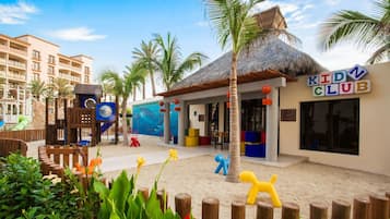 A children's play area with a pool, palm trees, and a building labeled 'KIDD CLUB'.