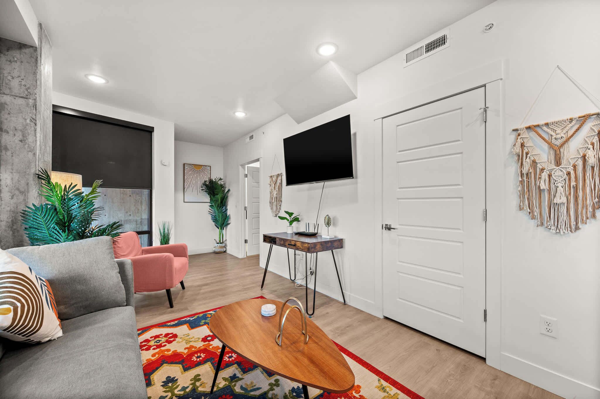 A modern living room with a sofa, coffee table, and a TV mounted on the wall.