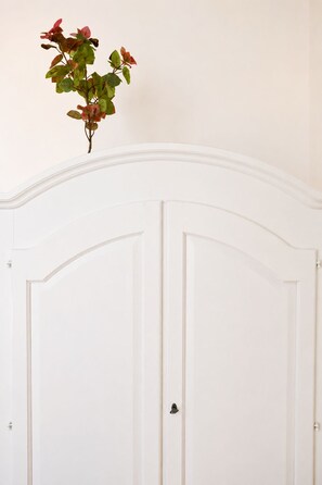 A white door with a simple handle and a plant with green and red leaves on top. - Caramanna Studio (Bologna)