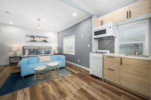 A compact living space with a kitchenette, a sofa, a dining area, and a bed. - West Oceanfront Oasis 2-3-7 (Newport Beach)