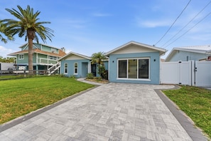 A residential property with a paved driveway leading to a house with a large window and a screened porch. - Waterfront Retreat: Swim Spa, Dock, Kayaks, Paddleboards & Gulf Access (Hudson)