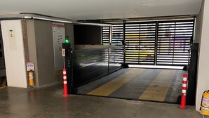 A parking garage entrance with a control panel, a fire extinguisher, and a striped safety mat. - A Sober and Elegant Loft Apartment in Chapinero (Bogotá)