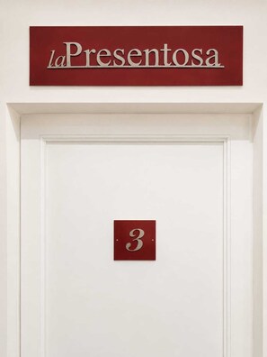 A door with a sign above it reading 'laPresentosa' and a number '3' on the door. - La Presentosa Studio Apartment (Bologna)