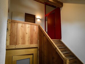 A wooden staircase with a red door at the top. - Chesa Tach by Interhome (Bever)