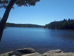 A calm lake with a forested shoreline and a clear sky. - Luxury house close to nature and a lake (Molnlycke)