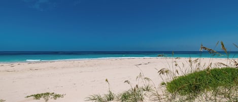 A beach with clear blue water and sand.