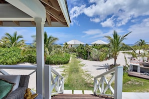 A wooden deck leading to a beach with palm trees and a clear sky. - Bohemia Bunkhouse - Steps to Pink Sand, Heated Pool (Governor's Harbour)
