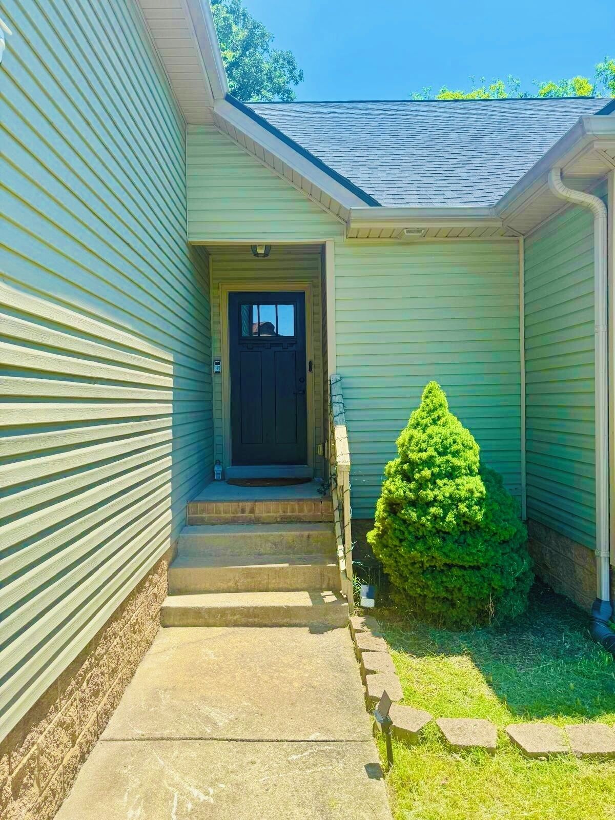 A house with a front door, a small front yard, and a mailbox.