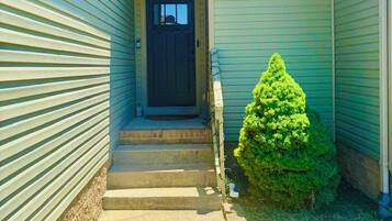 A house with a front door, a small front yard, and a mailbox.