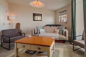 Ein gemütliches Wohnzimmer mit einer Couch, einem Couchtisch, einer Gitarre und einem Keyboard.