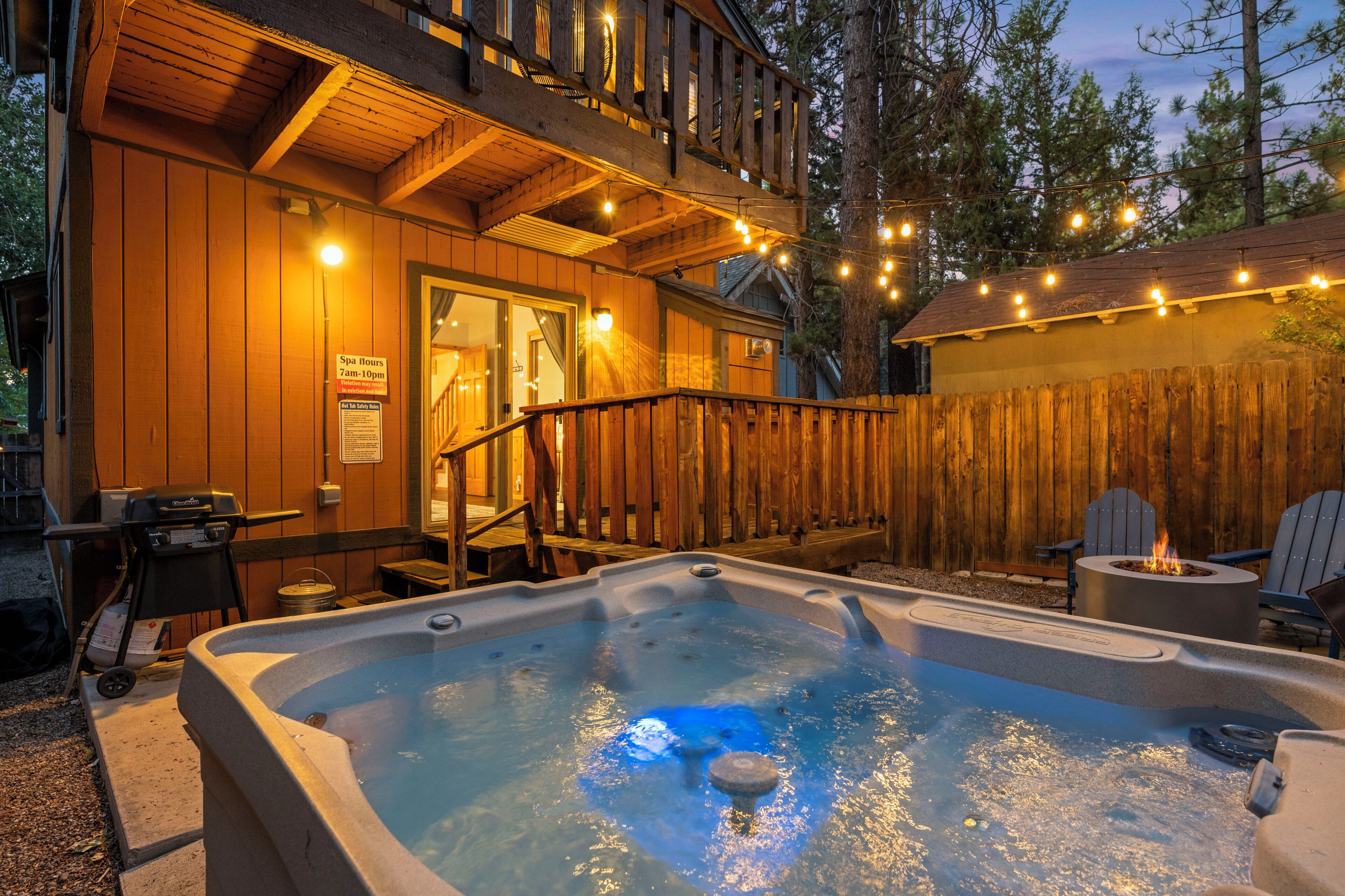 A wooden cabin with a hot tub and outdoor seating.