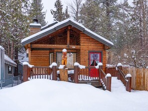 A wooden cabin with a red door, surrounded by snow-covered trees. - Cozy modern cabin in Lower Moonridge, 5 minutes from Big Bear Mountain! (Big Bear Lake)