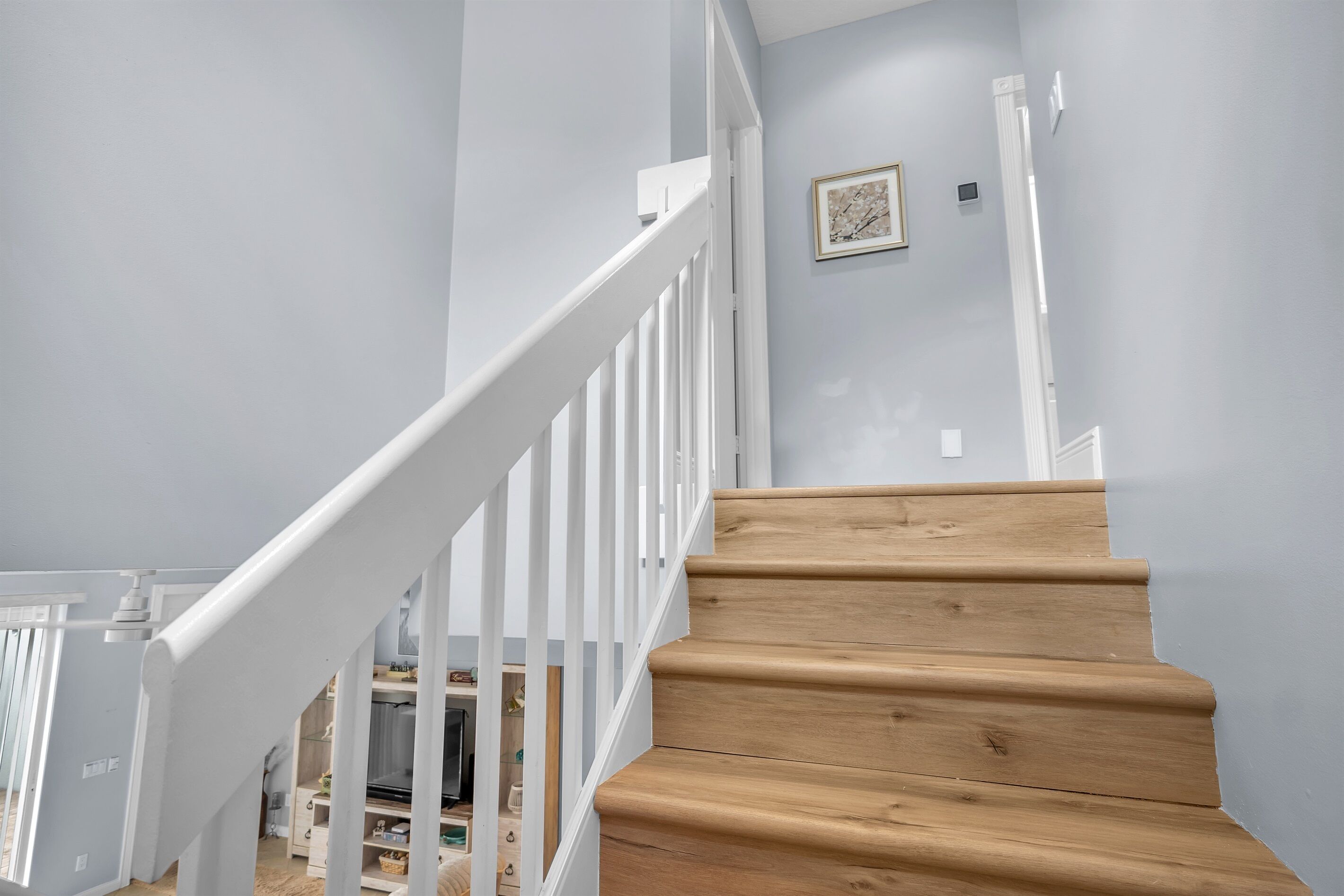 A wooden staircase with white railings leading to a landing.