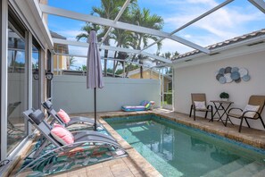 A swimming pool area with lounge chairs and a covered patio. - Bonita 3BR | Pool + Tennis | Monthly Min (Bonita Springs)