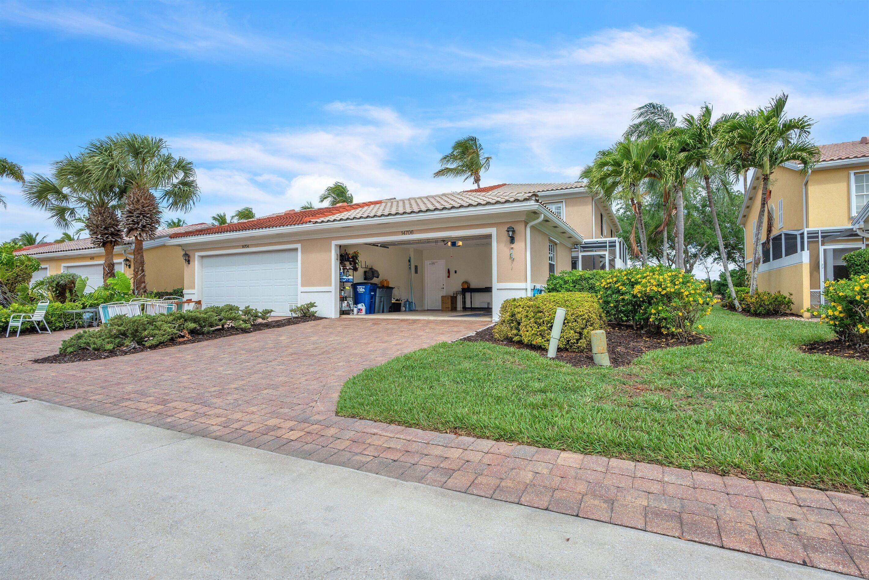 A residential property with a garage, a covered driveway, and a well-maintained lawn.