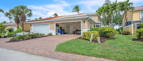A residential property with a garage, a covered driveway, and a well-maintained lawn.