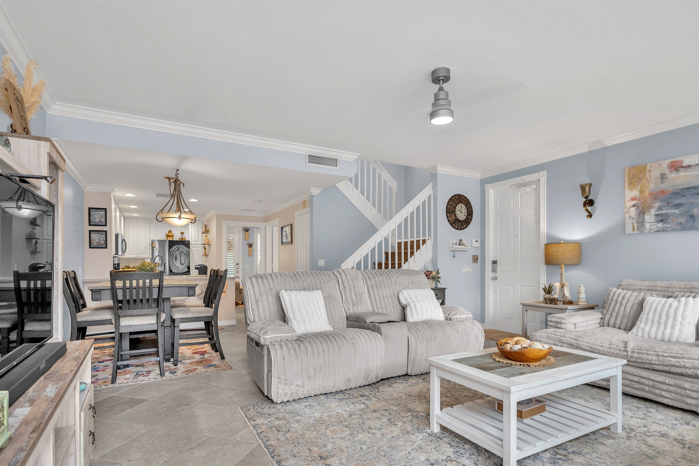 A spacious living room with a sofa, a coffee table, and a dining area with chairs and a table.