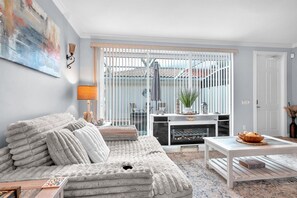 Een woonkamer met een bank, een salontafel en een open haard.