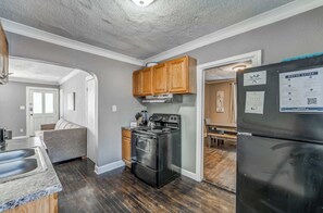 Una cocina moderna con estufa, horno y refrigerador, armarios de madera y un banco empotrado.