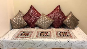 Ein Bett mit einer dekorativen Steppdecke und Pailettenkissen.