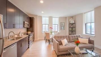 A modern apartment with a kitchen, dining area, and living room.