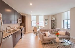 A modern apartment with a kitchen, dining area, and living room. - Harbor free indoor parking (Baltimore)