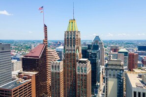 A cityscape with high-rise buildings, including a prominent Art Deco skyscraper with a spire and a flag.