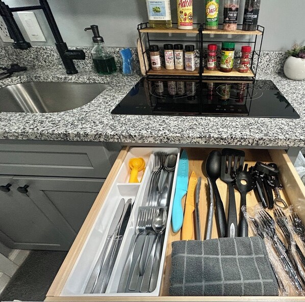 Una cocina con encimera de granito, un lavamanos integrado y un escurreplatos.