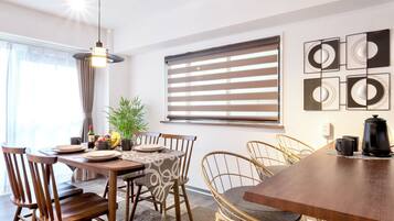 A dining area with a wooden table, chairs, and a coffee maker.