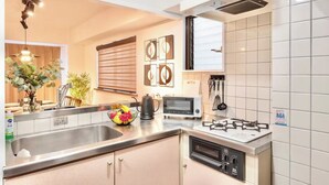Una cucina moderna con piano cottura a gas, forno integrato, lavello e un piano di lavoro con diversi elettrodomestici.
