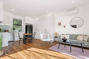 A modern living space with a kitchen, dining area, and seating area. - Brand-New Fernview 2BR w/ 2 Ensuites | Foothills (Ferntree Gully)