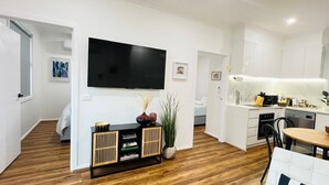 Een moderne woonkamer met een flatscreen televisie, een houten console en een bank.