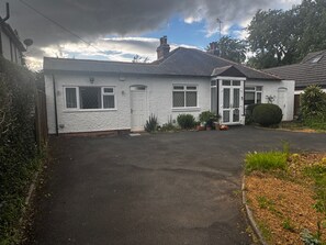 A single-story house with a front door, two windows, and a garage door. - Sleeps2-Studio-NearSolihull-FreeParking (Solihull)