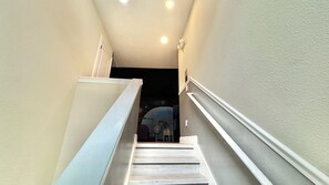 A narrow stairway with a handrail on both sides, leading to a room with a dark interior. - Spacious 8BR Disney-Area Home| Pool & Home Theater (Kissimmee)