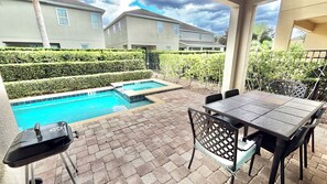 A backyard with a swimming pool, patio furniture, and a view of neighboring houses. - Spacious 8BR Disney-Area Home| Pool & Home Theater (Kissimmee)