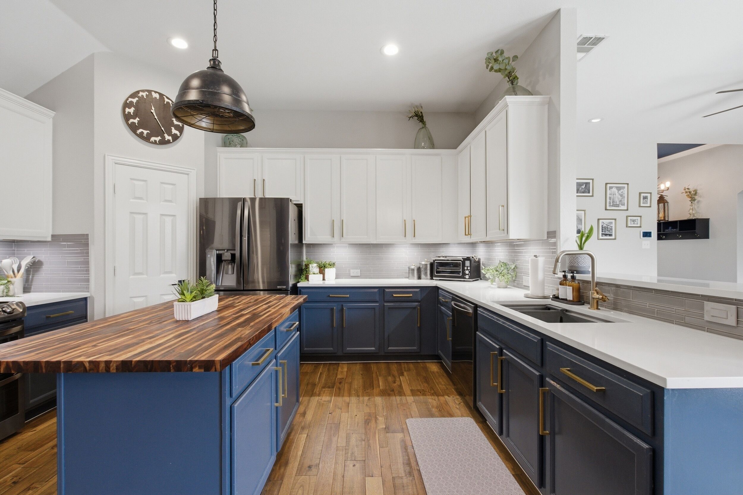 A modern kitchen with a central island, stainless steel appliances, and a variety of decorative items.
