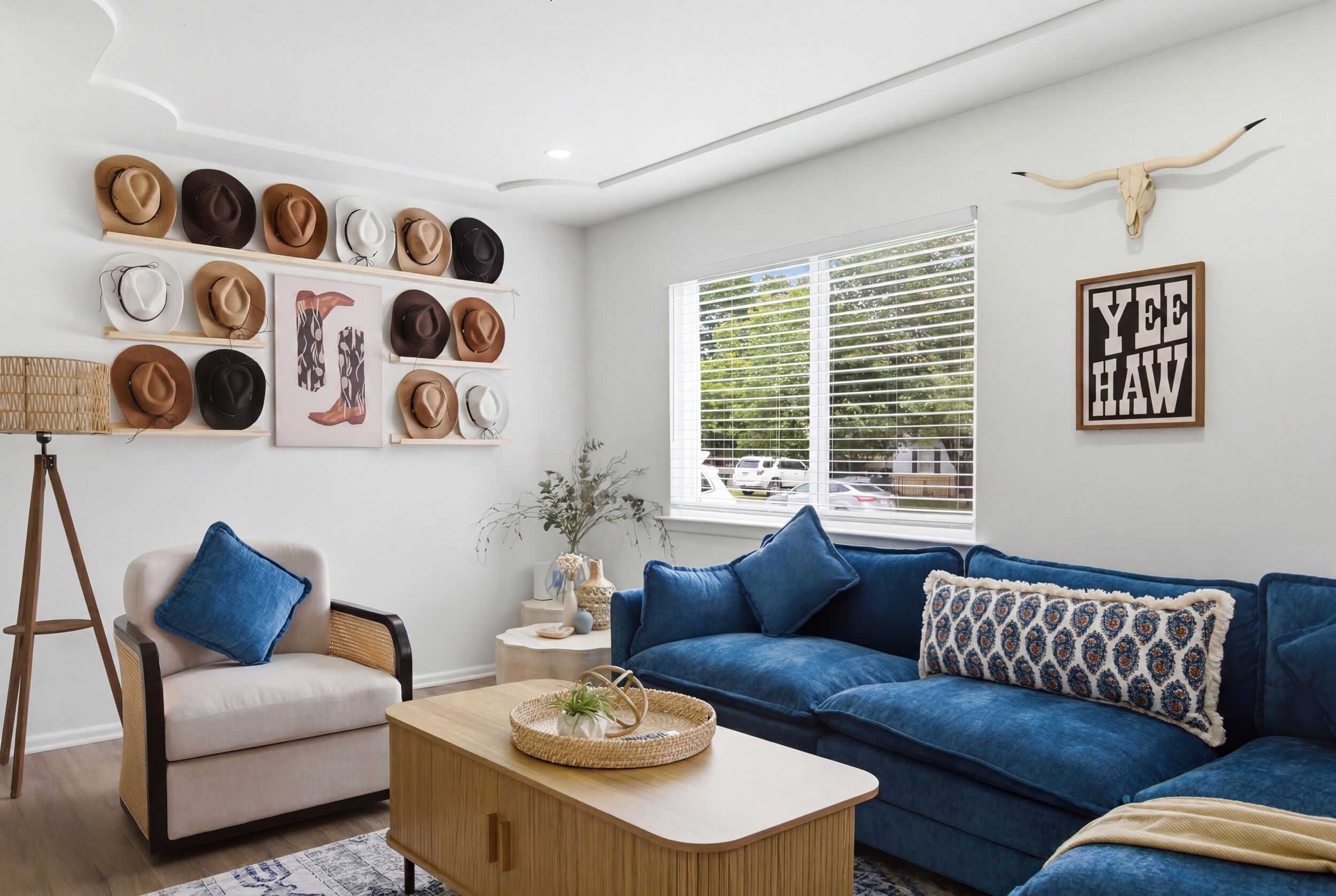 Una sala de estar moderna con un sofá azul, una mesa de centro y una colección de sombreros en estanterías.