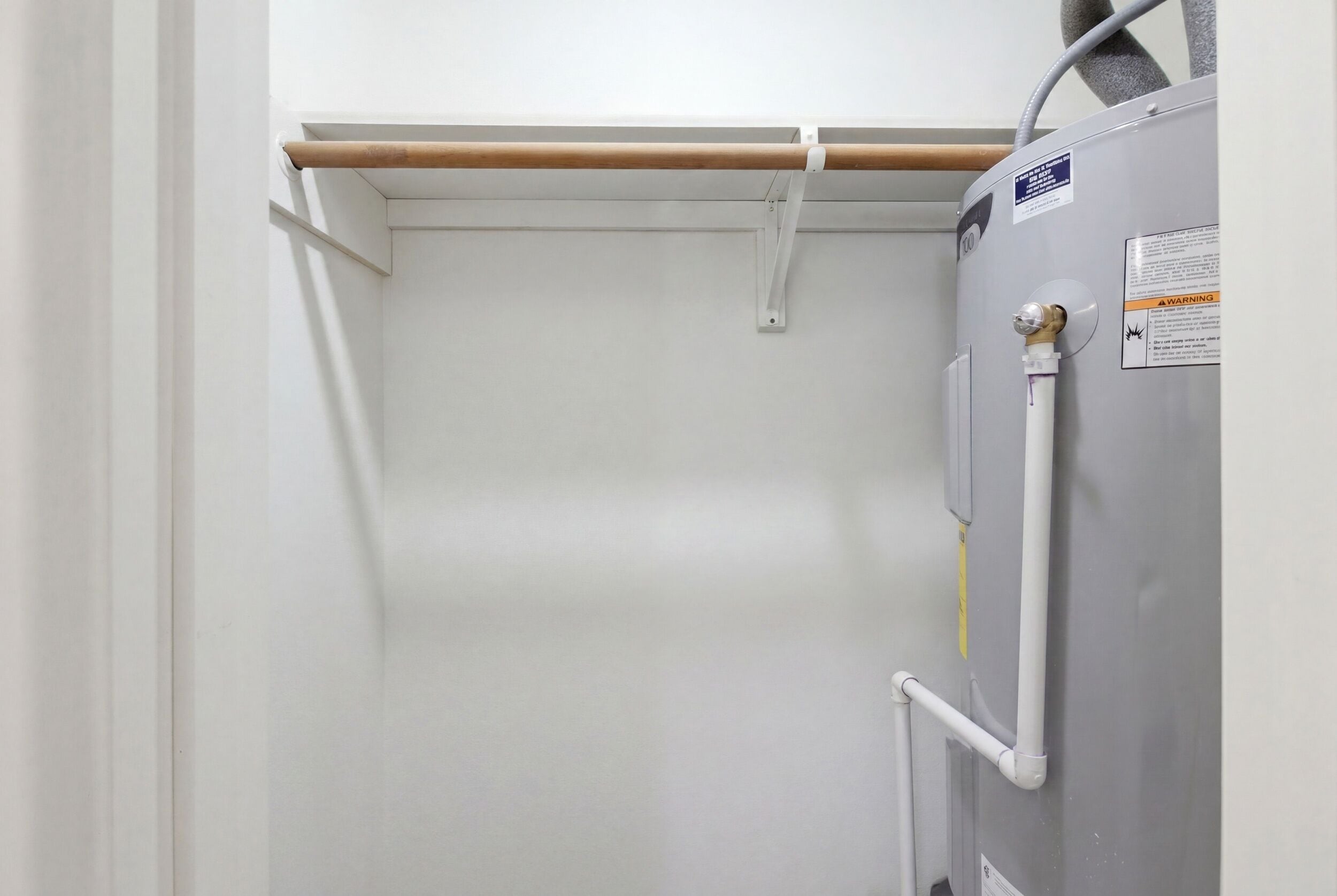 A room with a white door, a radiator, and a water pipe.