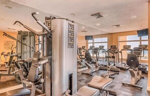 Ein Fitnessstudio mit verschiedenen Trainingsgeräten, darunter Laufbänder und Kraftgeräte.