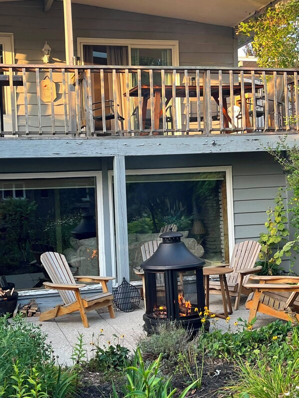 A two-story building with a balcony, outdoor seating area, and a fire pit.
