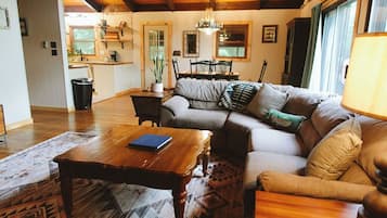 Un salon chaleureux avec une table basse en bois, un canapé agrémenté de coussins et un tapis à motifs.