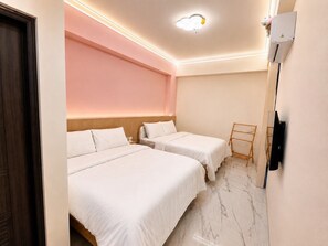 A hotel room with two beds, a wooden headboard, a wall-mounted TV, and a wooden hanger rack. - Wujie, Yilan private villa, ideal for families, friends and group stays. (Yilan County)